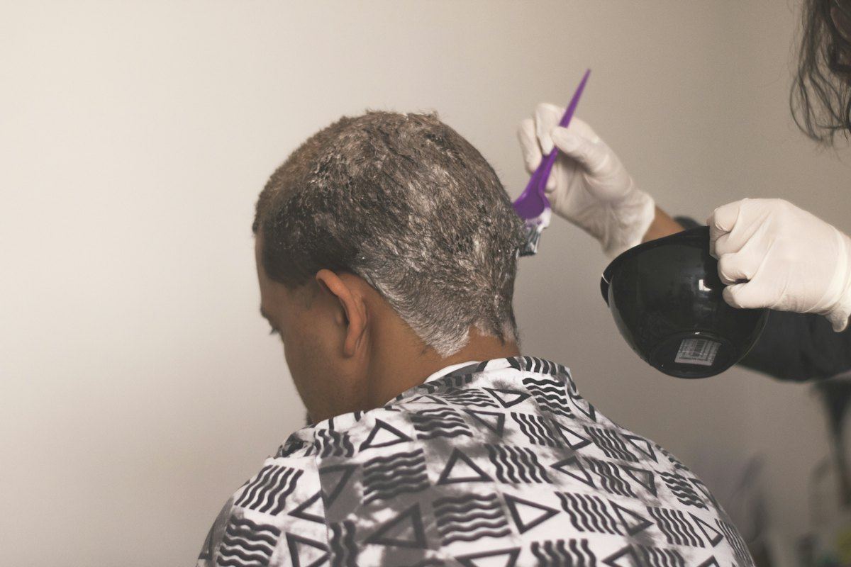 Colourist applying hair colour to cover greys